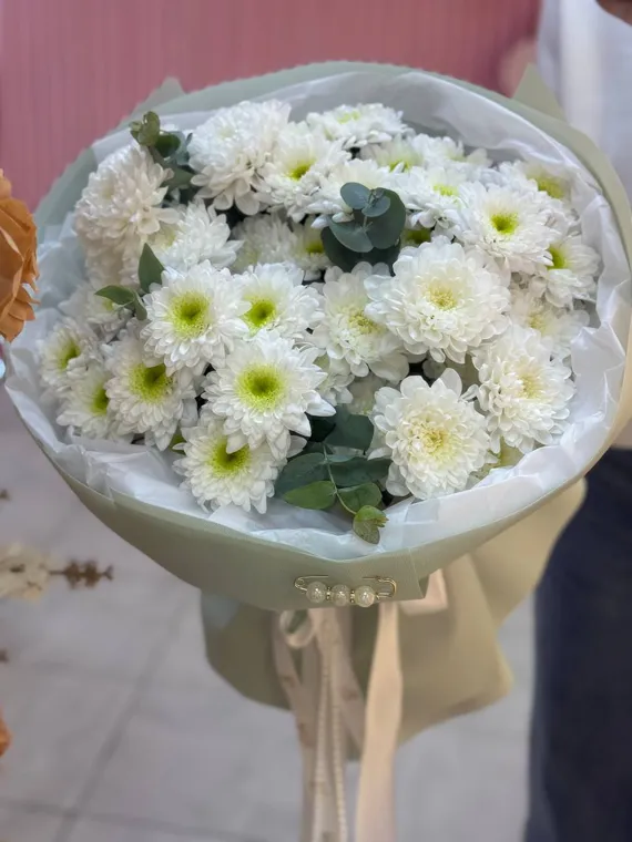 Белые ромашковидные цветы в прозрачной упаковке