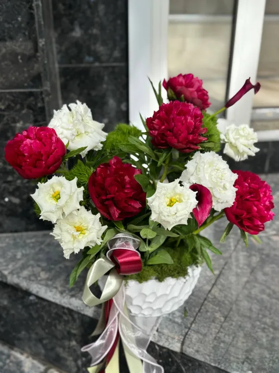 Красные розы и белые цветы в белой плетёной корзине